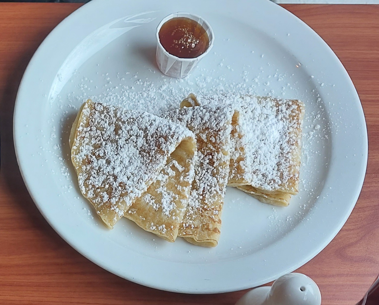 A plate full of pancakes with fresh syrup.